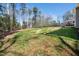 Spacious backyard featuring a lawn, mature trees, and stairs up to a deck at 139 Oswego Dr, Louisburg, NC 27549
