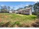 Grassy backyard with a view of the house, deck, and mature trees at 139 Oswego Dr, Louisburg, NC 27549