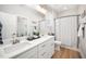 Bright bathroom with double vanity, large mirror, and shower with a striped curtain at 139 Oswego Dr, Louisburg, NC 27549