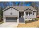 Charming exterior of a gray home with a gray garage door and beautiful front yard at 139 Oswego Dr, Louisburg, NC 27549