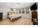 Spacious main bedroom with a tray ceiling, ceiling fan, and three large windows overlooking trees at 139 Oswego Dr, Louisburg, NC 27549