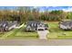 Aerial view features a well-kept home with a long driveway, surrounded by greenery and a tranquil street at 147 Everwood Dr, Four Oaks, NC 27524