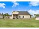 Spacious backyard featuring a well-maintained lawn and exterior view of the home with screened porch at 147 Everwood Dr, Four Oaks, NC 27524