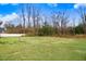 Large, grassy backyard surrounded by mature trees and fencing at 147 Everwood Dr, Four Oaks, NC 27524