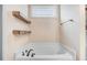 Clean and bright bathtub area with white tiles, modern fixtures, and natural light from the window at 147 Everwood Dr, Four Oaks, NC 27524