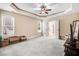 Spacious bedroom featuring tray ceilings, plush carpeting, and ample natural light for a cozy atmosphere at 147 Everwood Dr, Four Oaks, NC 27524