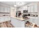 Stylish kitchen with white cabinets, granite counters, stainless appliances, and hardwood flooring at 147 Everwood Dr, Four Oaks, NC 27524