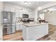 This kitchen features stainless steel appliances, white cabinets and a center island with granite countertops at 147 Everwood Dr, Four Oaks, NC 27524