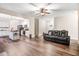 Spacious living room features a leather sofa, hardwood floors and adjacent kitchen and dining area at 147 Everwood Dr, Four Oaks, NC 27524
