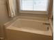 A bathtub with chrome faucet and window at 149 Steep Rock Dr, Willow Springs, NC 27592
