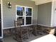 Inviting front porch with rocking chairs, creating a cozy outdoor space with stylish stone work at 149 Steep Rock Dr, Willow Springs, NC 27592