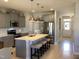 Open-concept kitchen with a center island, stainless steel appliances, modern lighting, and seamless flow to living space at 149 Steep Rock Dr, Willow Springs, NC 27592