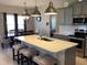 Open-concept kitchen with a center island, stainless steel appliances, modern lighting, and an adjacent dining area at 149 Steep Rock Dr, Willow Springs, NC 27592