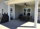 Covered patio with a ceiling fan, a dining table set and two grills for outdoor enjoyment at 149 Steep Rock Dr, Willow Springs, NC 27592