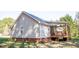 Home's rear view showcases a covered porch with a ceiling fan and wooden railing at 1516 Bradsher Dr, Stem, NC 27581
