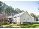 Home's rear view showcases a covered porch with a ceiling fan and wooden railing at 1516 Bradsher Dr, Stem, NC 27581