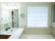 Bright bathroom featuring a bathtub and vanity with ample natural light at 1516 Bradsher Dr, Stem, NC 27581