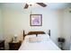 Cozy bedroom with ceiling fan, featuring a bed with a decorative pillow and framed floral picture at 1516 Bradsher Dr, Stem, NC 27581