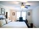 Spacious bedroom with a large bed, ceiling fan, and a dedicated workspace at 1516 Bradsher Dr, Stem, NC 27581