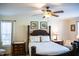 Comfortable bedroom with a four-poster bed, ceiling fan and natural light at 1516 Bradsher Dr, Stem, NC 27581