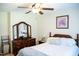 Bedroom with bed, wood dressers, ceiling fan, and a large mirror, showcasing comfortable living space at 1516 Bradsher Dr, Stem, NC 27581