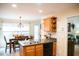 Kitchen area features oak cabinetry, double sink, modern appliances, and adjacent dining area at 1516 Bradsher Dr, Stem, NC 27581