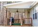 Outdoor covered porch with grill, ceiling fan, and wooded backyard at 1516 Bradsher Dr, Stem, NC 27581
