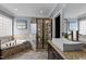 Bright bathroom with a soaking tub, glass shower, granite countertop, and modern fixtures at 1721 Frenchwood Dr, Raleigh, NC 27612