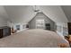 Spacious bonus room with neutral carpet, dormer window, built-in shelving, and a ceiling fan at 1721 Frenchwood Dr, Raleigh, NC 27612