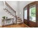 Foyer view showcasing the stairs with iron railings and front door with textured glass at 1721 Frenchwood Dr, Raleigh, NC 27612