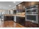 Modern kitchen boasts stainless steel appliances, granite countertops, and ample dark wood cabinet space at 1721 Frenchwood Dr, Raleigh, NC 27612