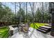 Outdoor patio with a dining set, lush landscaping, and a tree-lined backdrop for peaceful gatherings at 1721 Frenchwood Dr, Raleigh, NC 27612