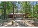Private backyard with mature trees, sunroom addition and outdoor seating area for relaxation at 1801 Irish Blvd, Sanford, NC 27332