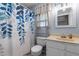 Neutral-colored bathroom features a leafy shower curtain, a white vanity, and silver fixtures at 1801 Irish Blvd, Sanford, NC 27332