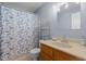 Bathroom featuring a blue shower curtain, an open shelving unit, and a light wood vanity at 1801 Irish Blvd, Sanford, NC 27332
