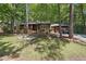 Charming, one-story home with wooded front yard, brown siding, and an American flag at 1801 Irish Blvd, Sanford, NC 27332