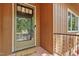The front door has storm door and is framed by dark wood siding and brick entryway at 1801 Irish Blvd, Sanford, NC 27332