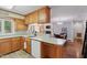 Kitchen with wooden cabinets and a view into a dining area featuring a fireplace at 1801 Irish Blvd, Sanford, NC 27332