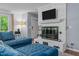 Bright living space with a white-painted brick fireplace, mounted television, and cozy blue sectional at 1801 Irish Blvd, Sanford, NC 27332