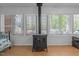 Cozy sunroom with wood burning stove, many windows, day bed and ceiling fan at 1801 Irish Blvd, Sanford, NC 27332