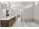Bathroom showcasing double sinks, a soaking tub with tile surround, and a walk-in shower at 1916 Edens Ridge Ave, Wake Forest, NC 27587