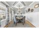 Charming dining room with wainscoting, coffered ceiling, and a stylish chandelier above the round table at 1916 Edens Ridge Ave, Wake Forest, NC 27587
