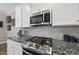 Close-up of kitchen featuring granite countertops, backsplash, and stainless steel appliances at 1916 Edens Ridge Ave, Wake Forest, NC 27587