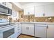 Bright kitchen features white cabinets, modern appliances, and tile backsplash at 220 Elizabeth St # F-2, Chapel Hill, NC 27514