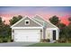 Two-story home with neutral siding, two car garage, landscaped yard and beautiful sunset at 2340 Beeblossom Pl, Fuquay Varina, NC 27526