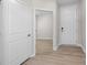 A hallway showcases wood-look flooring, crisp white doors, and natural light at 2340 Beeblossom Pl, Fuquay Varina, NC 27526