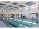 Bright indoor pool featuring lounge chairs and decorative lighting on the ceiling and walls at 2340 Beeblossom Pl, Fuquay Varina, NC 27526