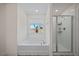 Bathroom featuring a garden tub, glass-enclosed shower, and large window offering natural light at 25 Carlton Ln, Franklinton, NC 27525