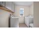Efficient laundry room with a window and wood look floors, complete with washer, dryer, and storage cabinets at 25 Carlton Ln, Franklinton, NC 27525