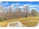 Backyard view from the elevated deck, showcasing a large lawn and mature trees at 250 Spring View Ln, Pittsboro, NC 27312